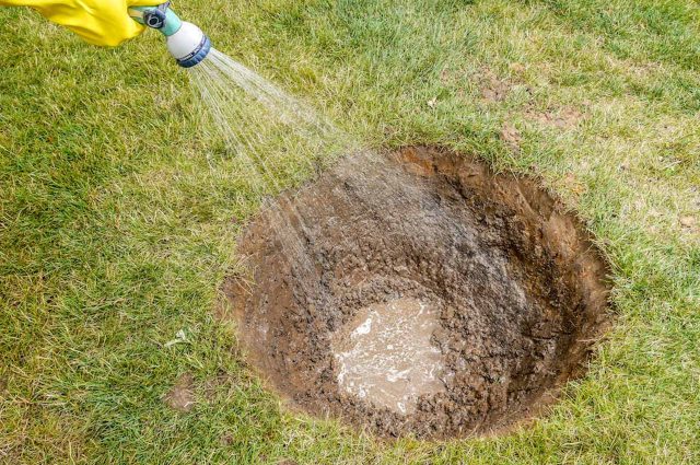 A hole in the ground being filled with water