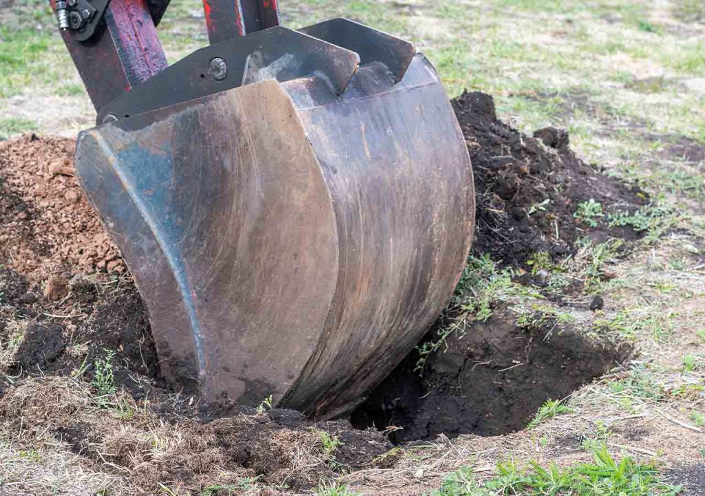 A digger, digging a hole in the ground.