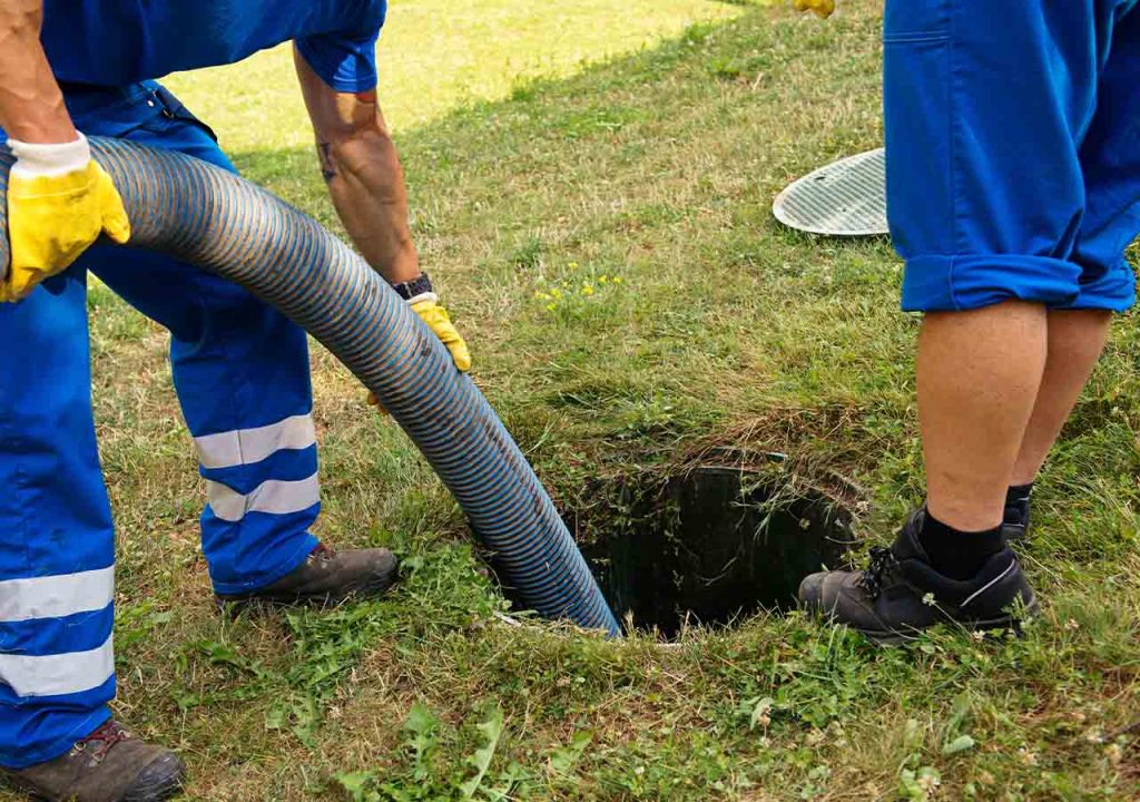 Draining a septic tank with a hose.