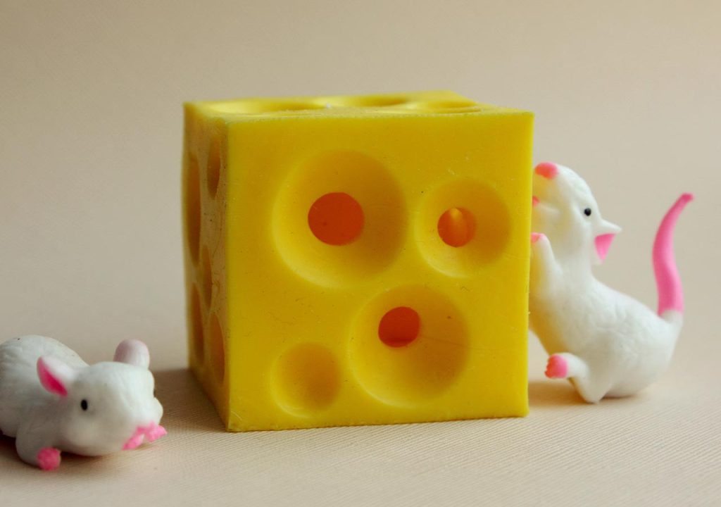 Two rubber mice with a block of rubber cheese.