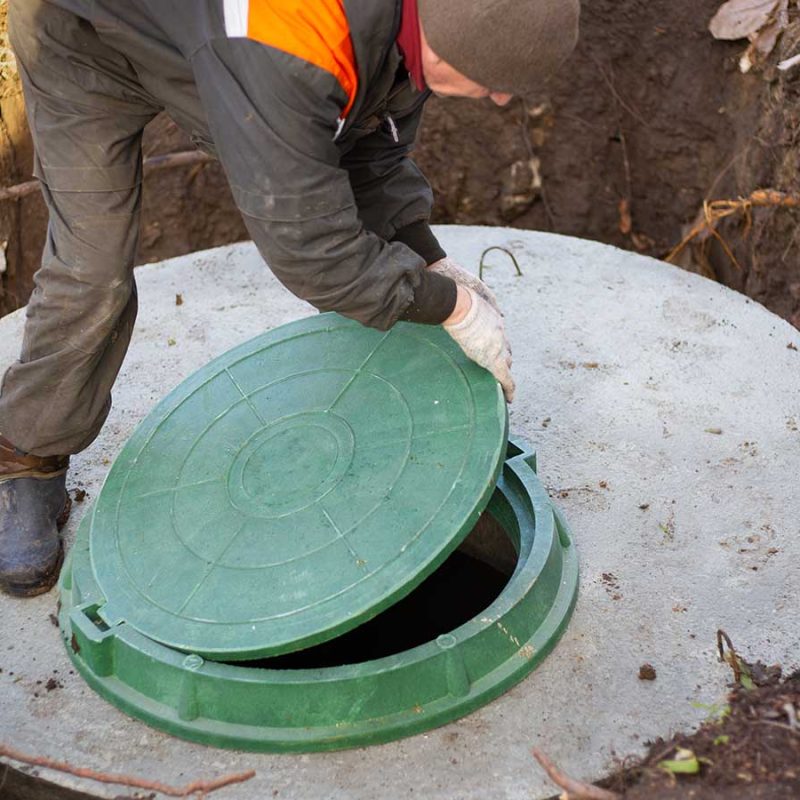 Raising the manhold cover of a septic tank.