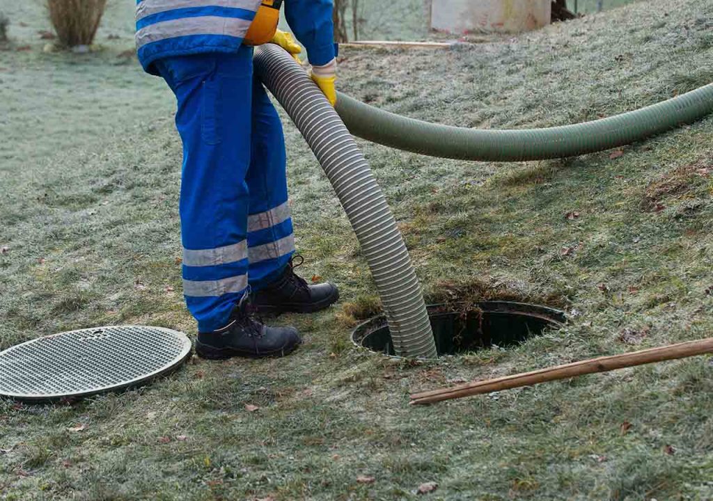 A person pumping a septic tank.