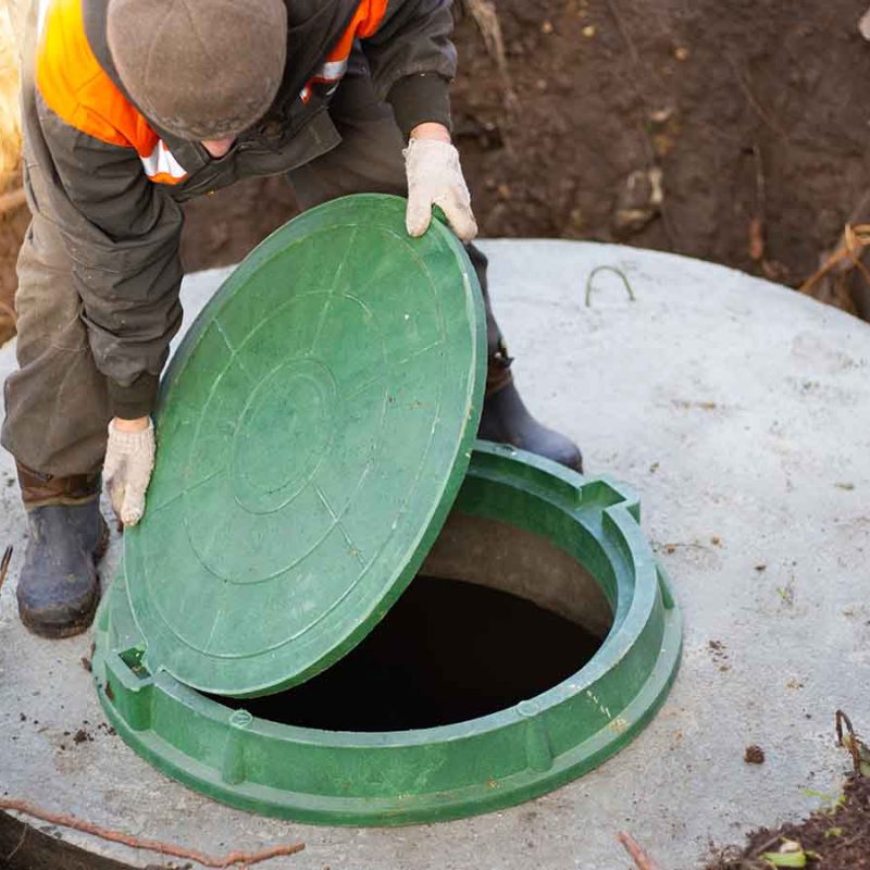 Closing a green manhole on a concrete septic tank.