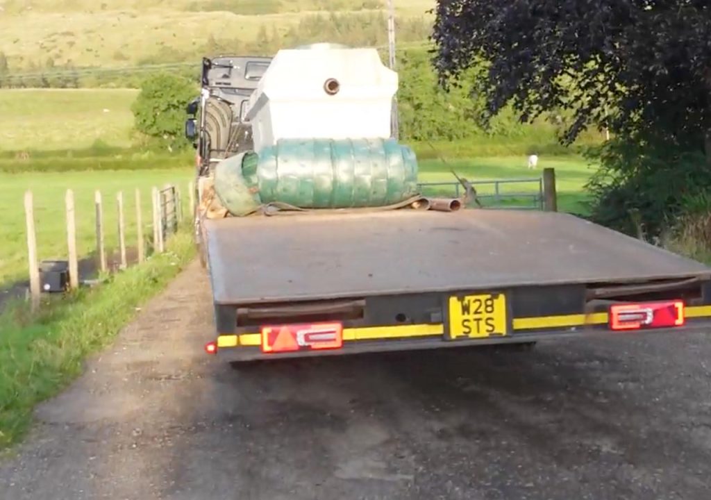 New sewage treatment tank on a truck going down a windy road.