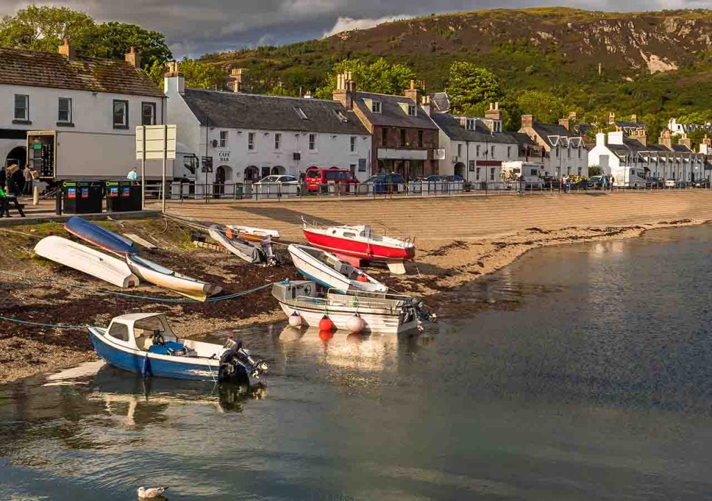 Ullapool with a line of cottages and boats by the water.