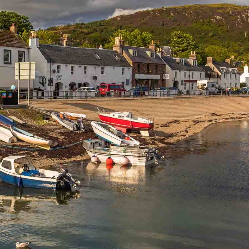 Ullapool with a line of cottages and boats by the water.