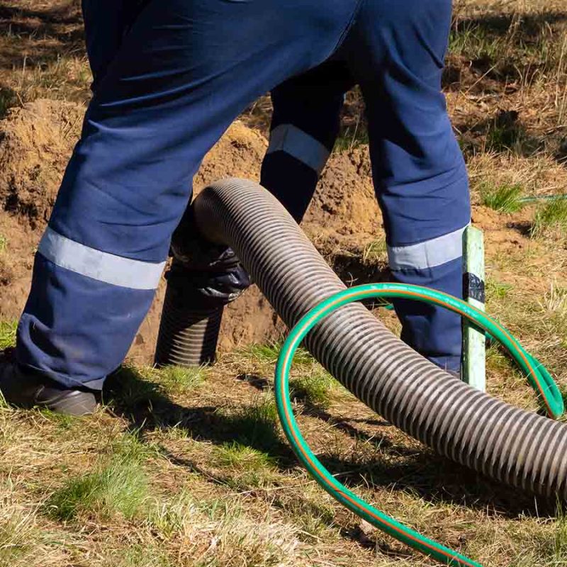 Using a pipe to take sludge out a tank.