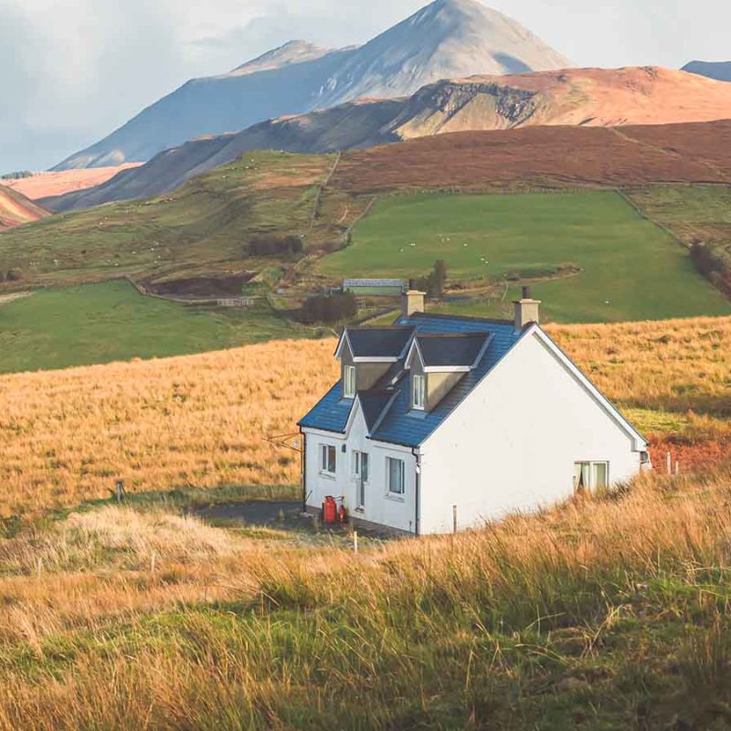 A house in Scotland at the foot of mountains.