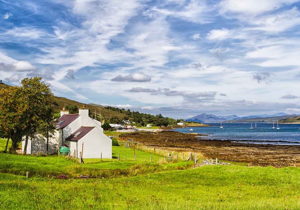 A house by the coast on a day with blue sky and clouds. 